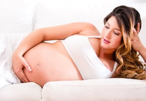Pregnant woman lying on the sofa at home